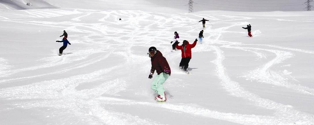 Groep snowboardt samen door de verse sneeuw