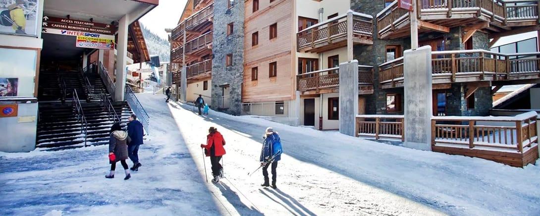 Kinderen lopen door een besneeuwde straat in Châtel