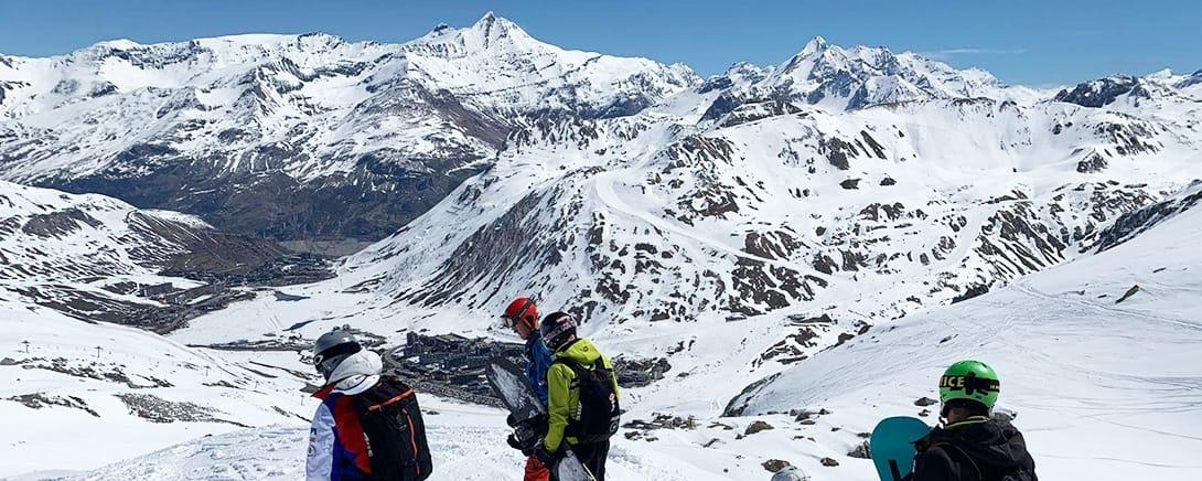 Skiërs kijken uit over het besneeuwde landschap van Tignes