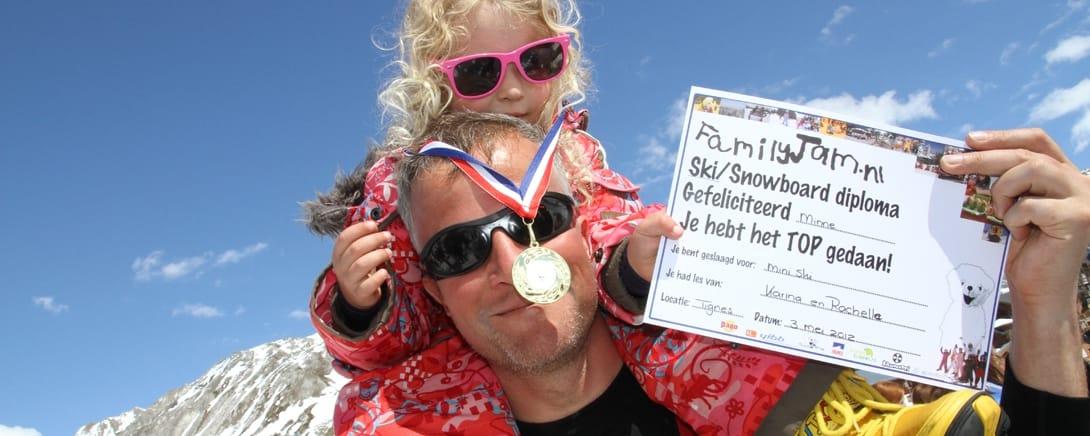 Kind met medaille en Family Jam ski-diploma op de piste