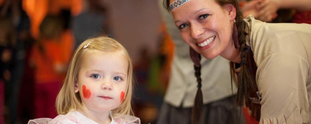 Moeder en dochter met beschilderde wangen tijdens een Family Jam activiteit