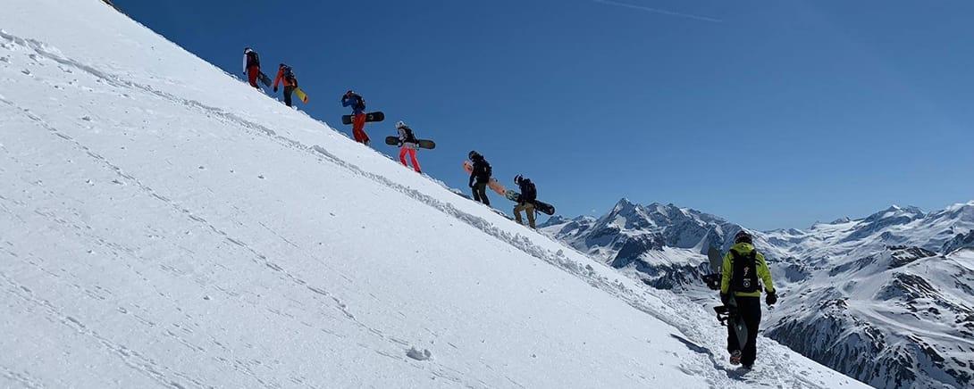 Groep skiërs beklimt een besneeuwde bergrug